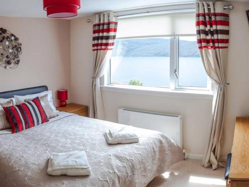 a bedroom with a bed and a large window at Ardlair Guest House in Ullapool