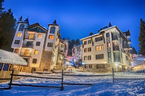 eine Gruppe von Gebäuden im Schnee in der Nacht in der Unterkunft The Castle Complex in Pamporowo