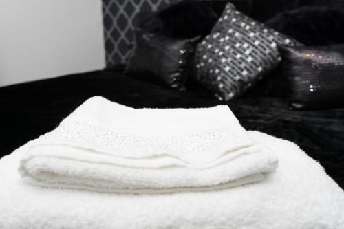 ハルにあるHullidays - Theatre Side Apartment - Refurbished 2023のベッドの上に置かれた白いタオルの山