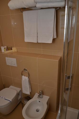 a bathroom with a sink and a toilet and towels at Chateau Royal Hotel in Berezovka