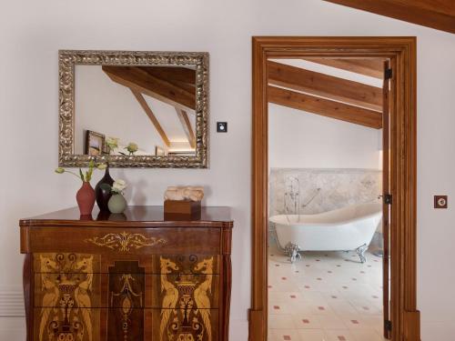 a bathroom with a tub and a mirror at Hotel Gloria de Sant Jaume in Palma de Mallorca