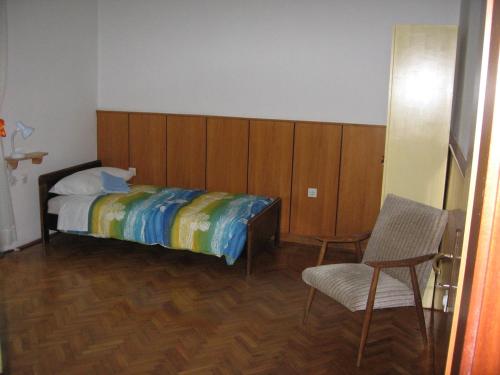 a bedroom with a bed and a chair at Guest House Rože in Ilirska Bistrica