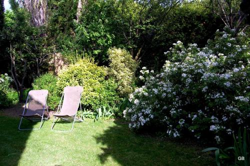 two chairs sitting in the grass in a garden at Le Mas des Clots in Upie