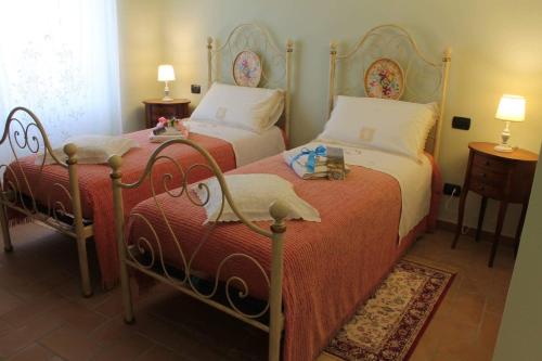 a bedroom with two beds and two tables and two lamps at La terrazza fio...Rita in Ripa