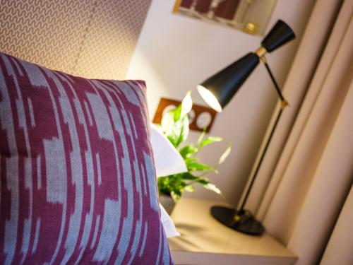 a lamp sitting on a table next to a bed at Hotel Gloria de Sant Jaume in Palma de Mallorca