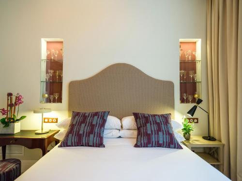 a bedroom with a white bed with two pillows at Hotel Gloria de Sant Jaume in Palma de Mallorca