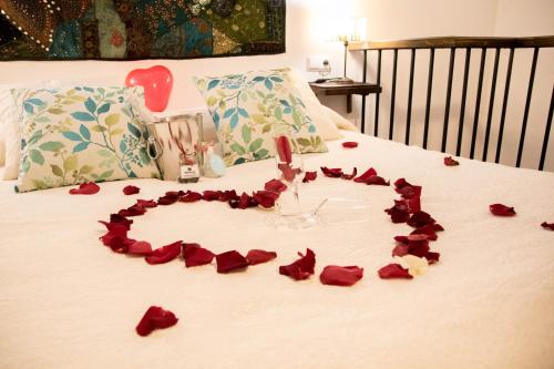 a heart made out of roses on a bed at Cazorla Rural in Quesada