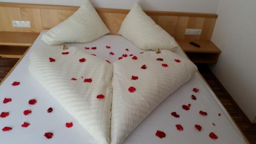 a bed with red hearts on the sheets at Apart Luneta in Ladis