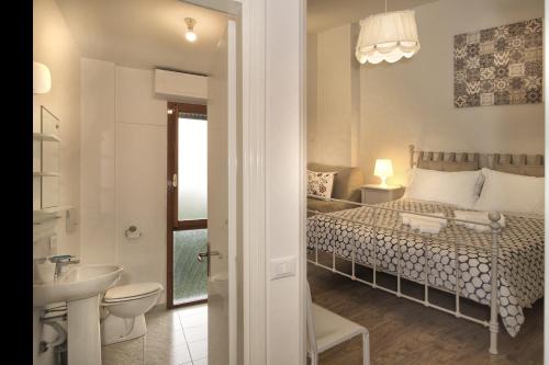 a bedroom with a bed and a bathroom with a sink at Affittacamere BB STEFY in Pisa