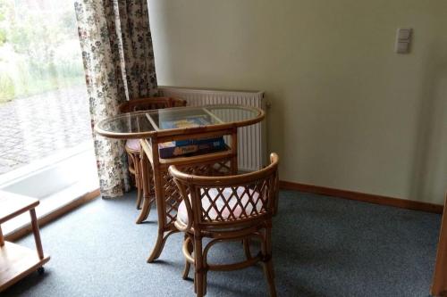 a table and chairs in a room with a window at Entspannung in der schönen Lüneburger Heide in Göhrde