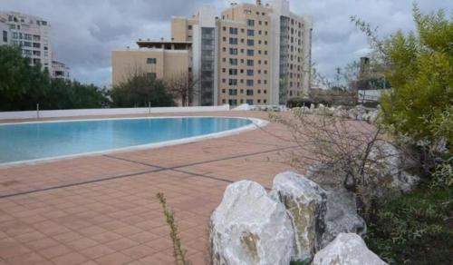a swimming pool in a city with tall buildings at Apartamento Ideal 2 in Lisbon