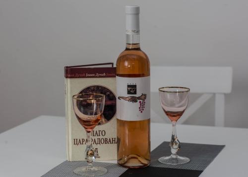 a bottle of wine and two glasses on a table at Apartment Marko in Trebinje