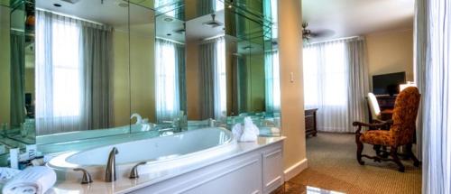 a bathroom with a large tub and a large mirror at Hotel Bentley in Alexandria
