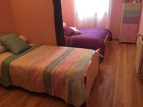 a bedroom with two beds and a mirror at Chambres à Nogaro in Nogaro