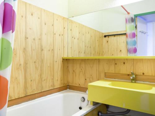 La salle de bains est pourvue d'un lavabo jaune et d'une baignoire. dans l'établissement Residence Les Constellations - maeva Home, à Belle Plagne