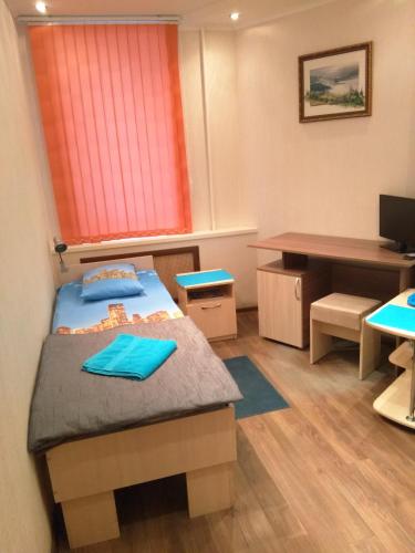 ペルミにあるHotel Esplanadaのベッドとデスクが備わる小さな客室です。