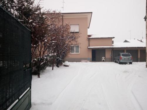 a snow covered driveway with a car parked in a house at B&B delle Arti in Crema