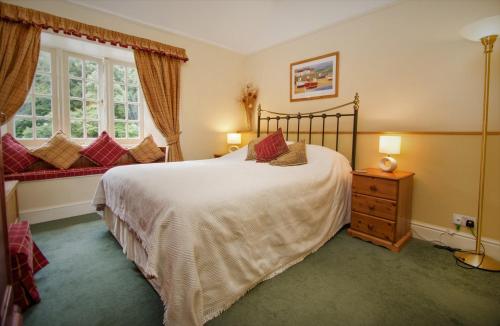 A bed or beds in a room at Polraen Country House Hotel