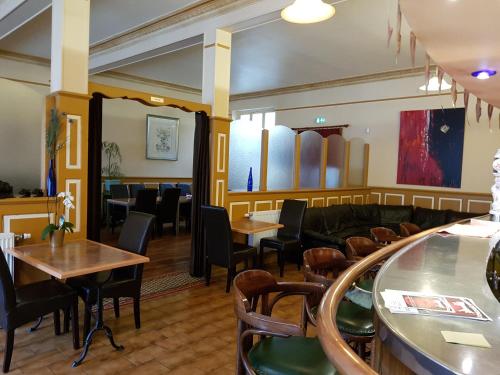 - un restaurant avec des tables, des chaises et un canapé dans l'établissement Hotel Restaurant La Sirène, à Étain