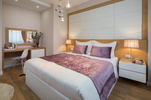 a bedroom with a large bed with purple pillows at VIP Rooms in Split