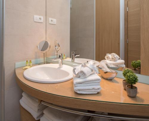 a bathroom with a sink and a mirror and towels at VIP Rooms in Split