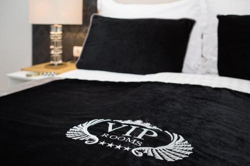 a bed with a black comforter with a rhino logo on it at VIP Rooms in Split