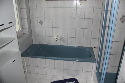 W pokoju znajduje się łazienka z niebieską wanną. w obiekcie Ferienwohnung Haus Cerny w mieście Bad Goisern
