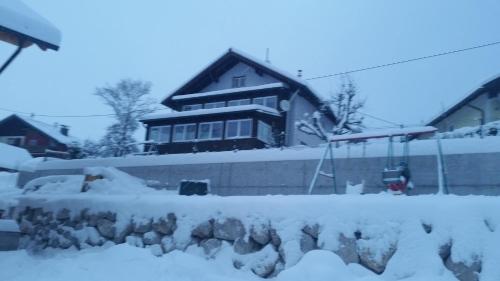 a house with a pile of snow in front of it at Ferienwohnung Haus Cerny in Bad Goisern