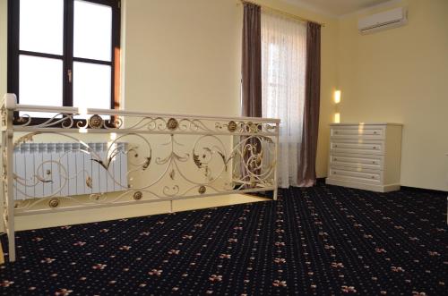 a bedroom with a bed and a dresser in a room at Chateau Royal Hotel in Berezovka