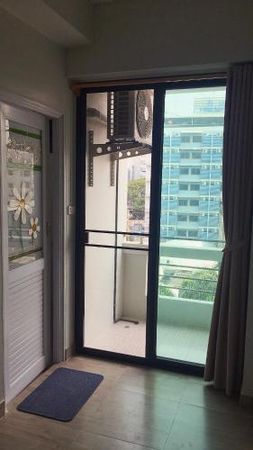 a room with a sliding glass door with a view of a building at Vanlisut Hotel Ngamwongwan in Nonthaburi
