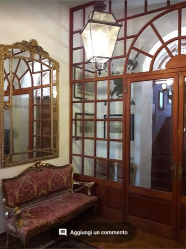 a living room with a chair and a mirror at Villa Chiarenza Maison d'Hotes in Giardini Naxos