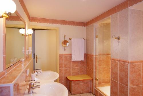 a bathroom with two sinks and a shower at Hotel & Restaurant Sonne in Kirchzarten