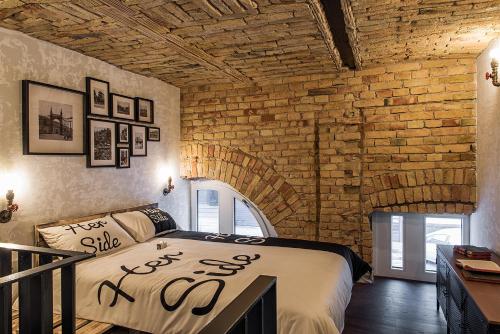 ブダペストにあるImagine Budapest Loft Apartmentsのレンガの壁、ベッド付きのベッドルーム1室