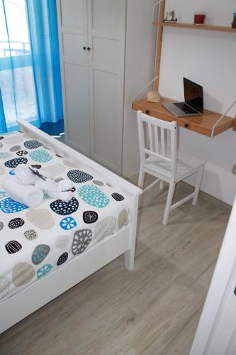 Schlafzimmer mit einem Bett und einem Schreibtisch mit einem Laptop in der Unterkunft "A Livanti" B&B in Marzamemi