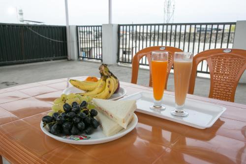 Una mesa con un plato de comida y dos vasos de cerveza. en Hotel Shiv Kripa, en Dehradun