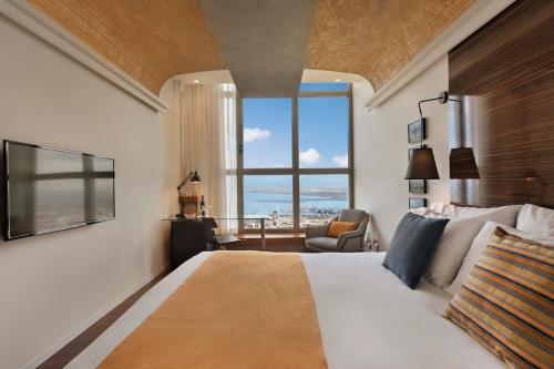a bedroom with a large bed with a large window at Haifa Bay View Hotel By AFI Hotels in Haifa