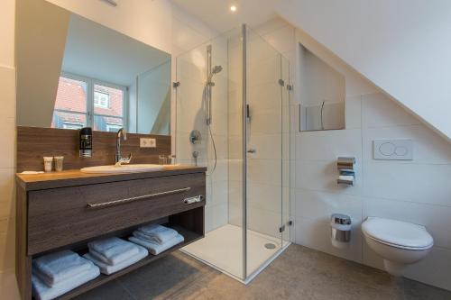 a bathroom with a shower and a sink and a toilet at Hotel am Schrannenplatz in Memmingen