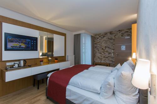 a hotel room with a large bed and a desk at Hotel am Schrannenplatz in Memmingen