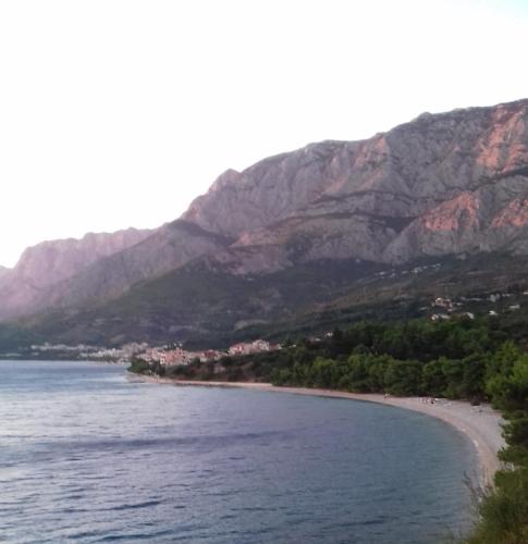 a view of a beach with mountains in the background at Studio with magic view in Podgora