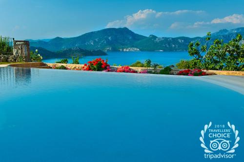 einen großen Pool mit Blick auf das Wasser in der Unterkunft Swan Lake Hotel - Adult Only in Selimiye