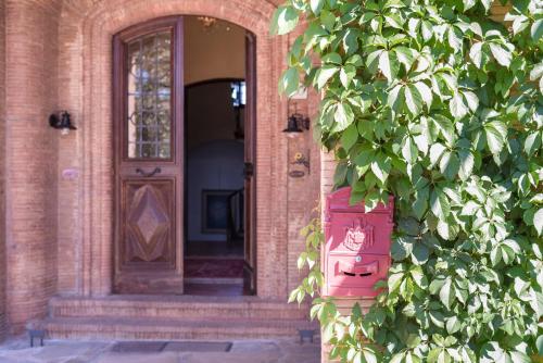 a front door of a brick building with a tree at Fattoria Pian Di Rocca in Castiglione della Pescaia