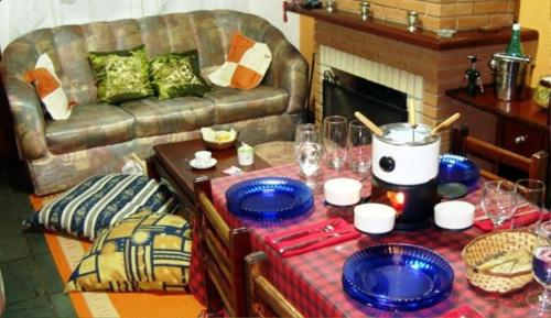a living room with a couch and a table with blue plates at Chalé Suiço de Campos do Jordão in Campos do Jordão