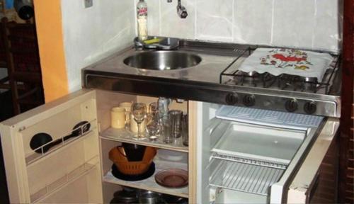 a kitchen with a sink and a stove and a sinkessment at Chalé Suiço de Campos do Jordão in Campos do Jordão