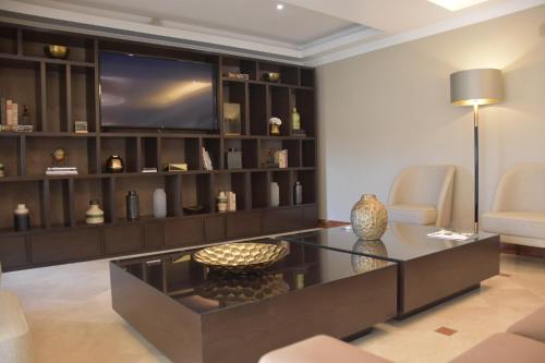 a living room with a tv and a coffee table at Hotel Suave Mar in Esposende
