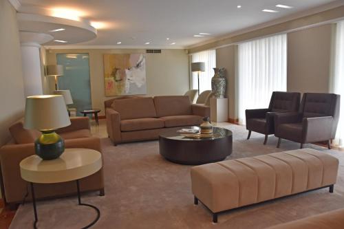 a living room with couches and a table and chairs at Hotel Suave Mar in Esposende