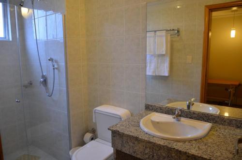a bathroom with a toilet and a sink and a shower at Barbur Plaza Hotel in Ponta Grossa
