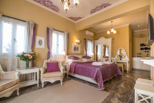 Schlafzimmer mit einem Bett mit lila Bettwäsche und einem Spiegel in der Unterkunft Symi Nautilus Luxury Suites in Symi