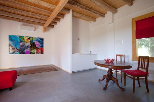 Ca' Adami في Brussa: غرفة معيشة مع طاولة وكراسي ولوحة