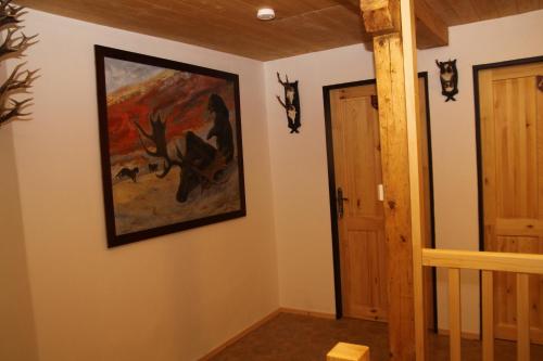 a hallway with a painting on the wall and a door at apartmány pod Vysákem in Stárkov