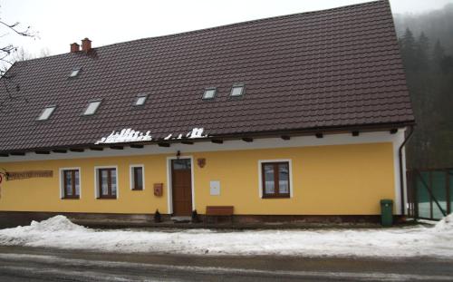 een geel gebouw met een bruin dak bij apartmány pod Vysákem in Stárkov